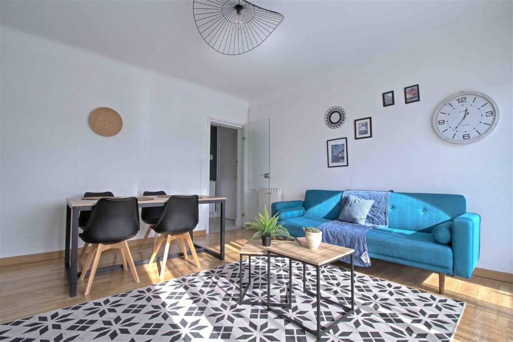a living room with a blue couch and a table at ADELITAS House in Agen