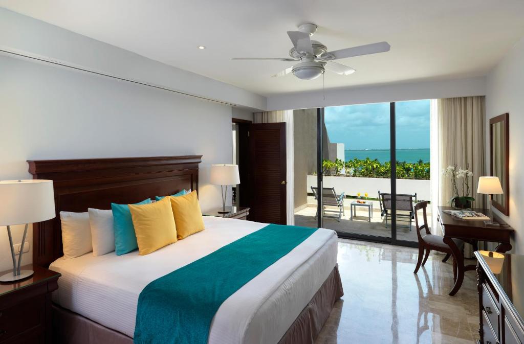 a bedroom with a large bed with a view of the ocean at Paradisus Cancun All Inclusive in Cancún