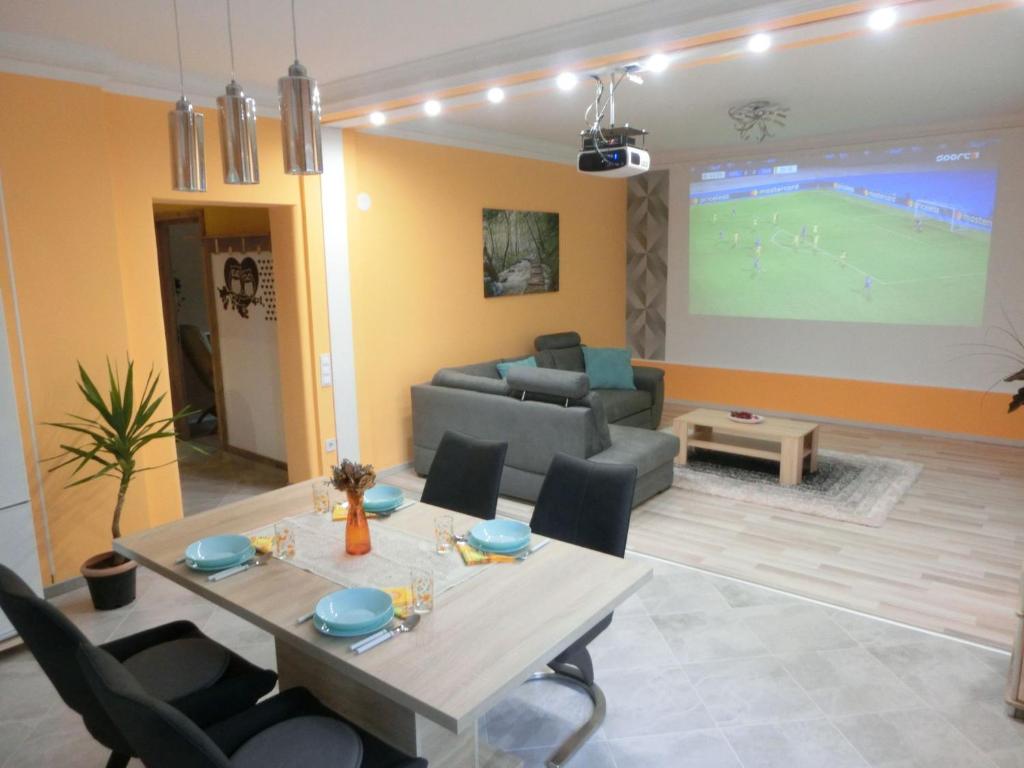 a living room with a table and a couch at Pilis Apartman in Piliscsaba