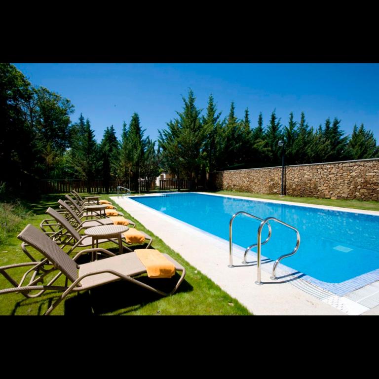 grupa leżaków i basen w obiekcie Parador de Puebla de Sanabria w mieście Puebla de Sanabria