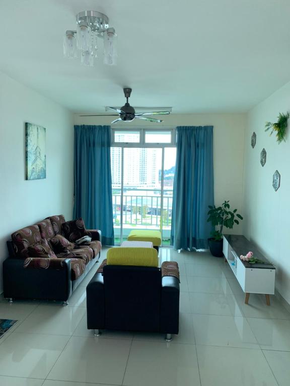 a living room with a couch and blue curtains at 4R3B Cozy, Spice Arena/PISA View Houze B.Lepas in Bayan Lepas