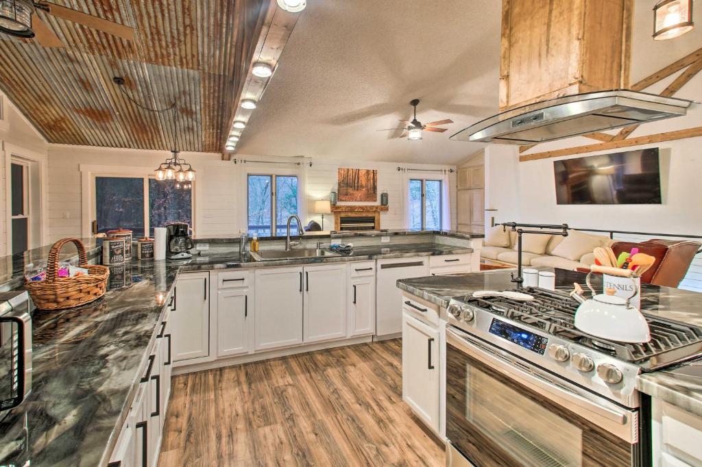 a kitchen with white cabinets and a stove top oven at 15 Mi to Hot Springs Natl Park Home with Fire Pit! in Hot Springs Village