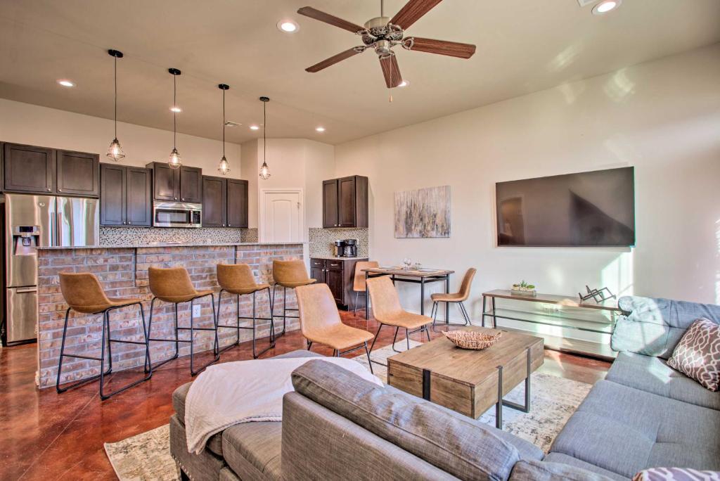 a living room with a couch and a bar at Edmond Oasis with Rooftop Lounge Walk to Dtwn! in Edmond