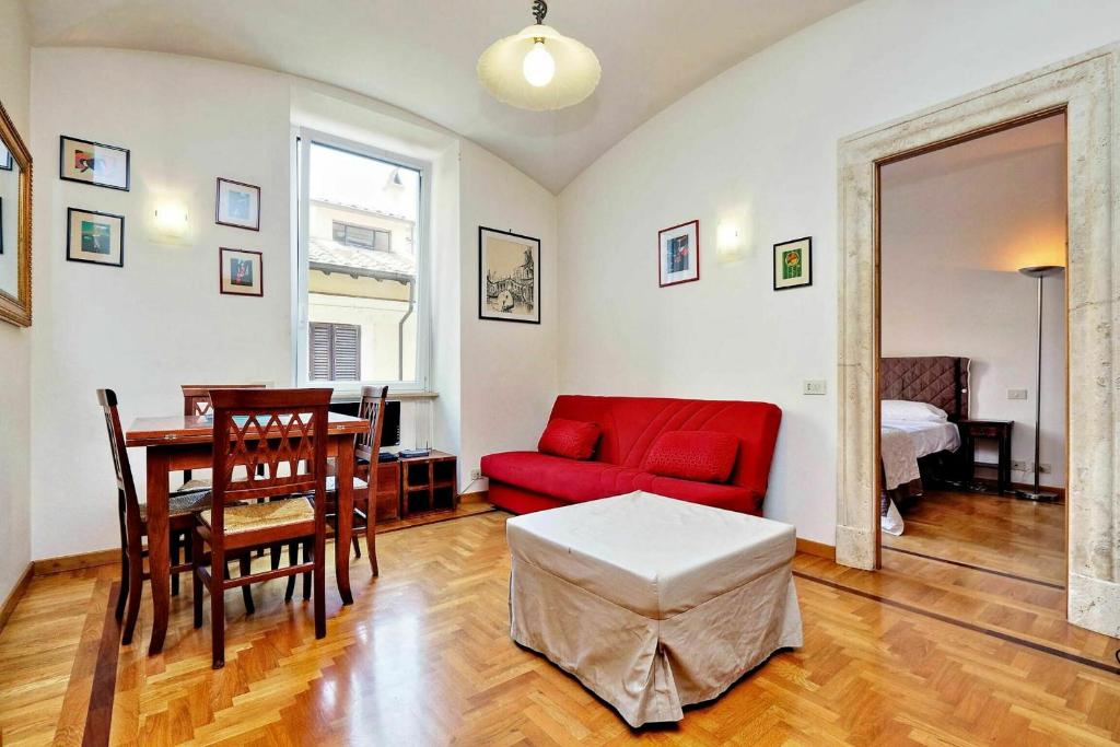 un soggiorno con divano rosso e tavolo di Borgo Pio a Roma