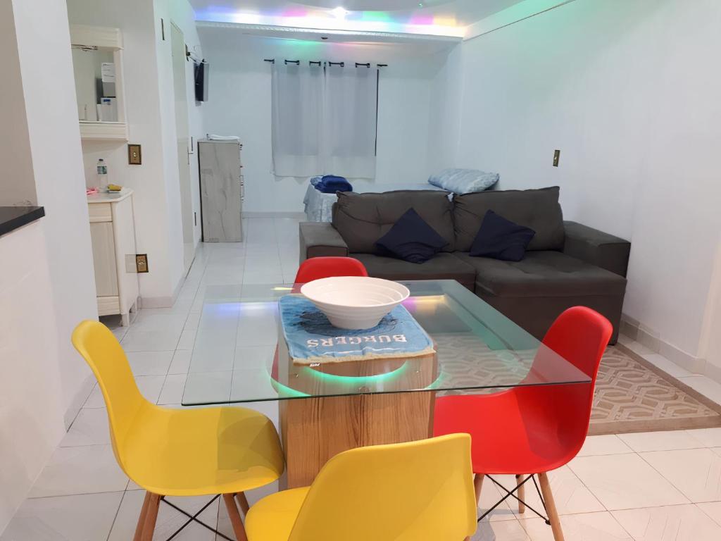 a living room with a glass table and chairs at Apartamento A 43 Flat Centro in Mogi das Cruzes