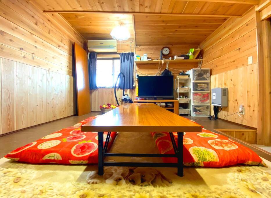 uma sala de estar com uma mesa e um sofá em 普光寺 em Kawaba