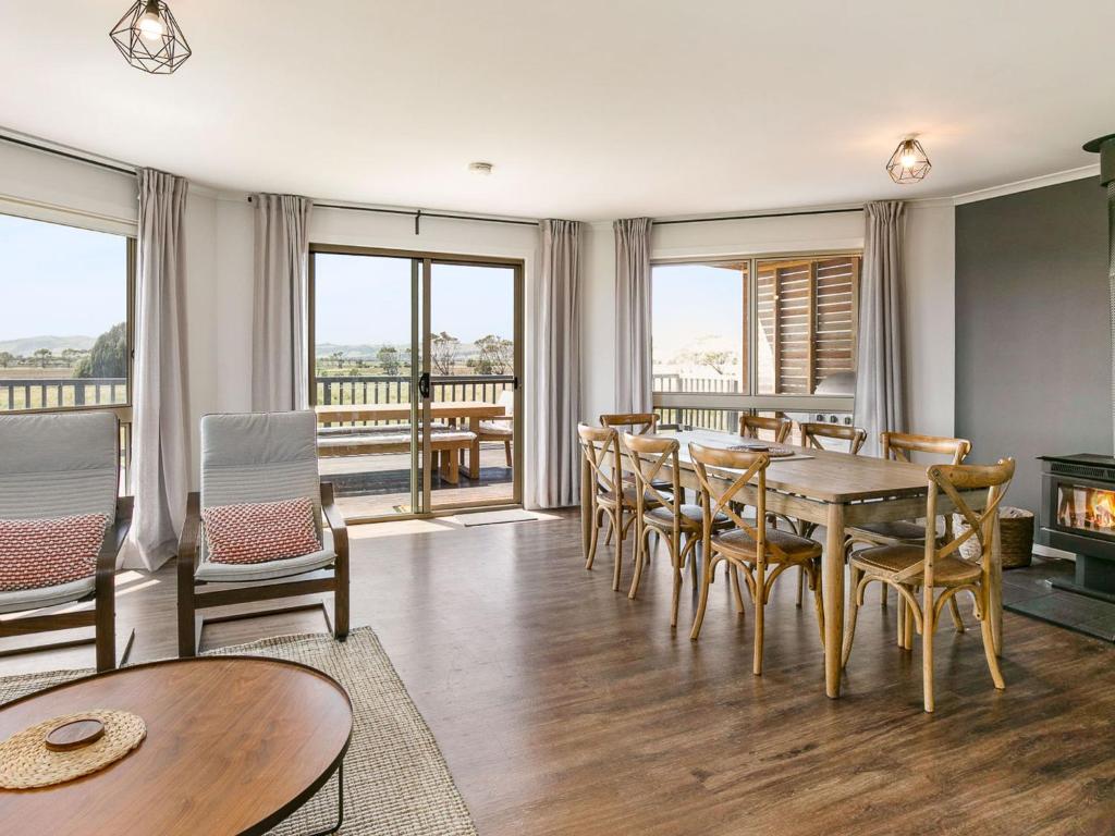 a dining room with a table and chairs and a fireplace at Bass River Farm in Bass