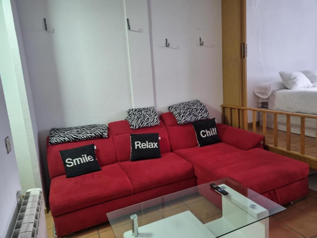 czerwona kanapa w salonie z łóżkiem w obiekcie LOS VALLES ELITE w mieście Sierra Nevada