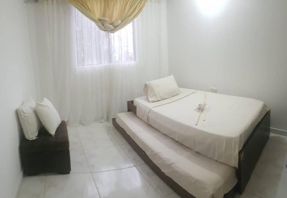 ein weißes Schlafzimmer mit einem Bett und einem Fenster in der Unterkunft Casa de Descanso El Diamante in Restrepo