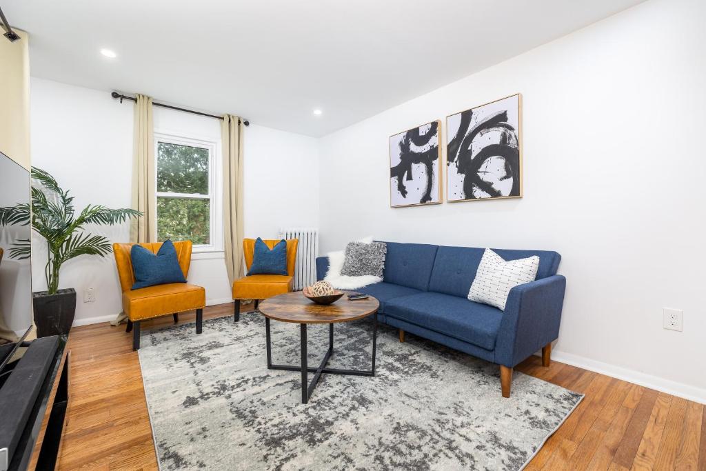 een woonkamer met een blauwe bank en 2 stoelen bij Lovely Ranch House in Windsor, 10 mins to Hartford Connecticut in Windsor