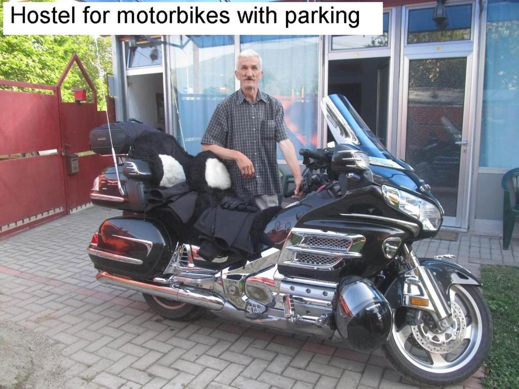 a man standing next to a motorcycle with a dog in it at Motel Le Village in Skopje