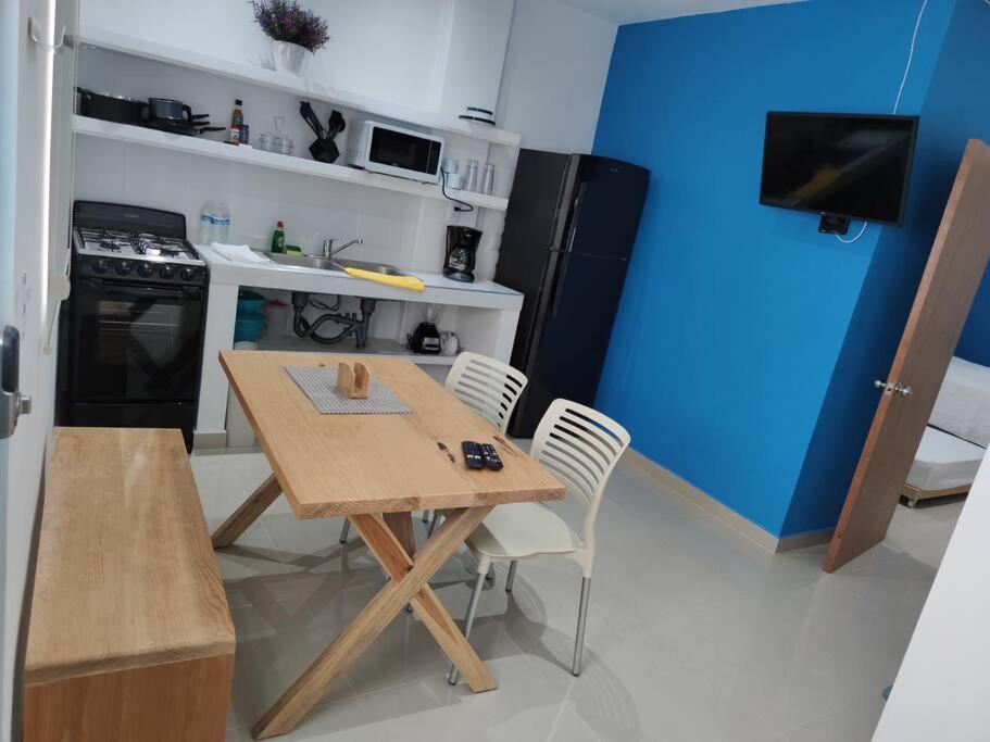 eine kleine Küche mit einem Holztisch und Stühlen in der Unterkunft Azul departamento 34 m2 Nuevo in Jiutepec
