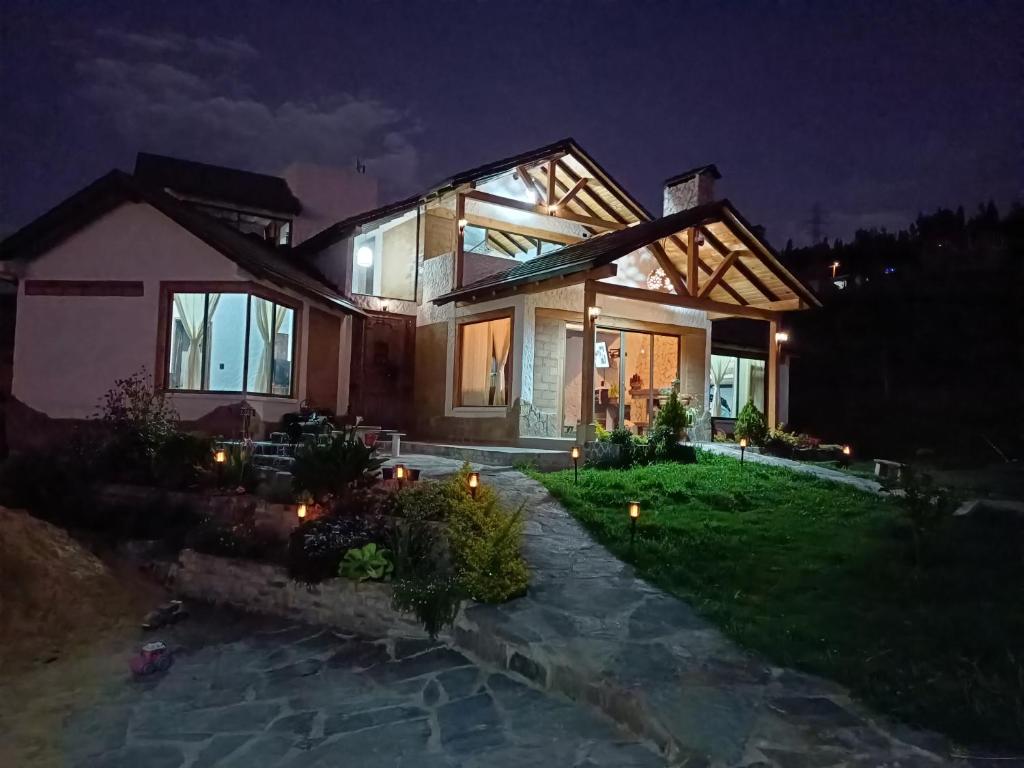 Una casa se ilumina por la noche en Cabaña El Encanto De ALU, en Paipa