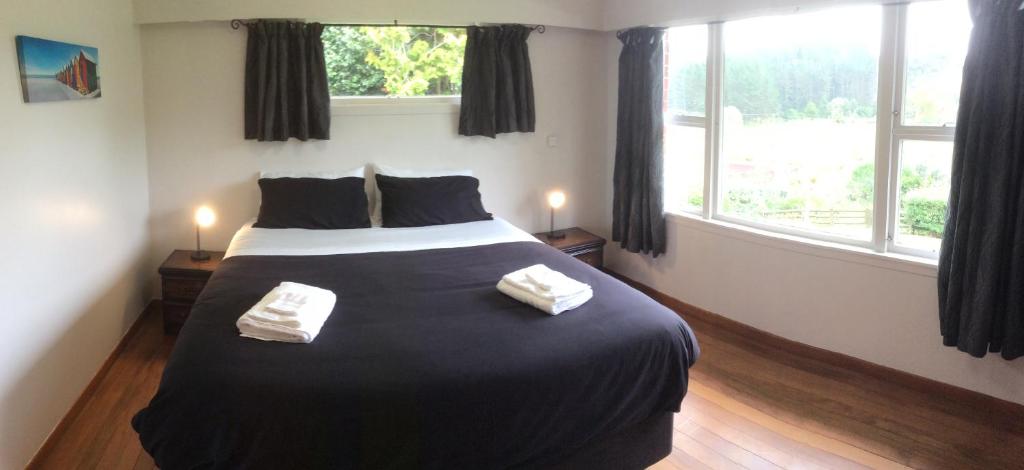 sypialnia z dużym łóżkiem z dwoma ręcznikami w obiekcie Hill top view farm stay w mieście Uruti