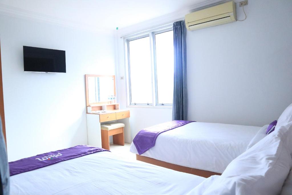 Postel nebo postele na pokoji v ubytování Plum Hotel Lading Banda Aceh
