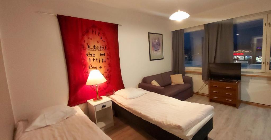 イヴァロにあるIvalo Apartmentのベッド、ソファ、テレビが備わるホテルルームです。