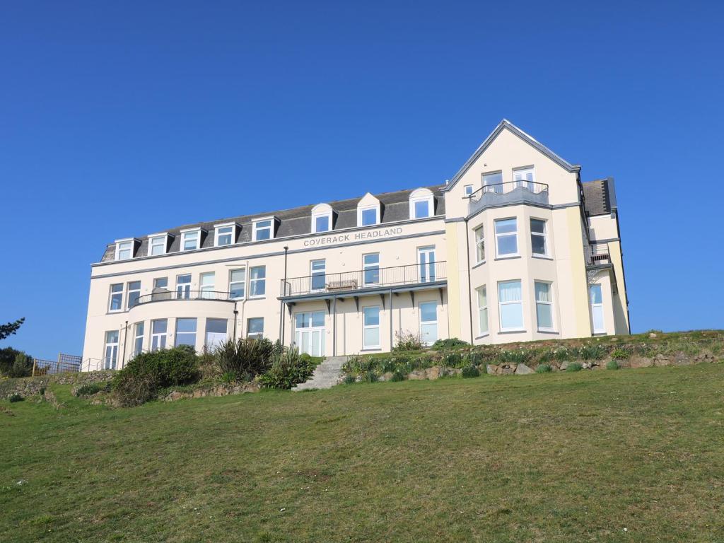 a large white building on top of a hill at Headland Apt 17 in Coverack