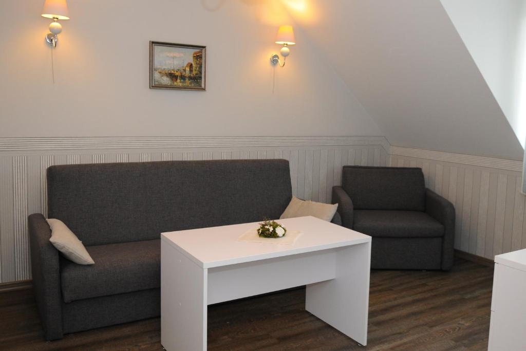 a living room with a couch and a table at Pension Villa Karmelia in Darlowko