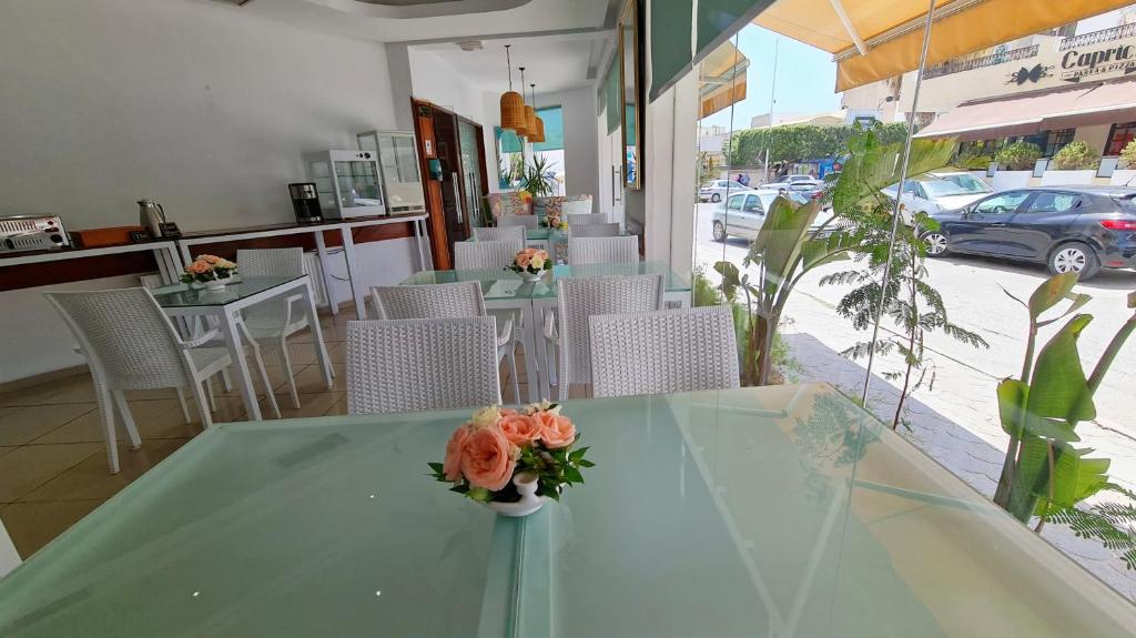 a table with a vase of flowers on it in a restaurant at Hotel Khella in Hammamet
