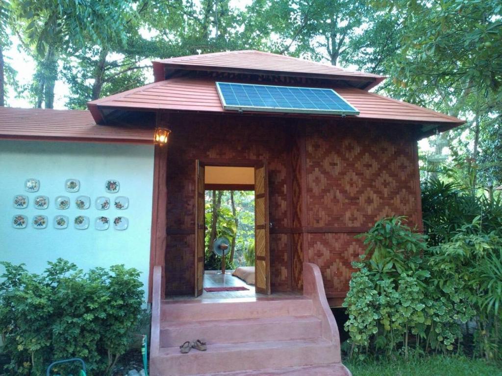 Banpainamhomestay في Ban Huai Thalaeng Phan: منزل صغير مع لوحة شمسية على السطح