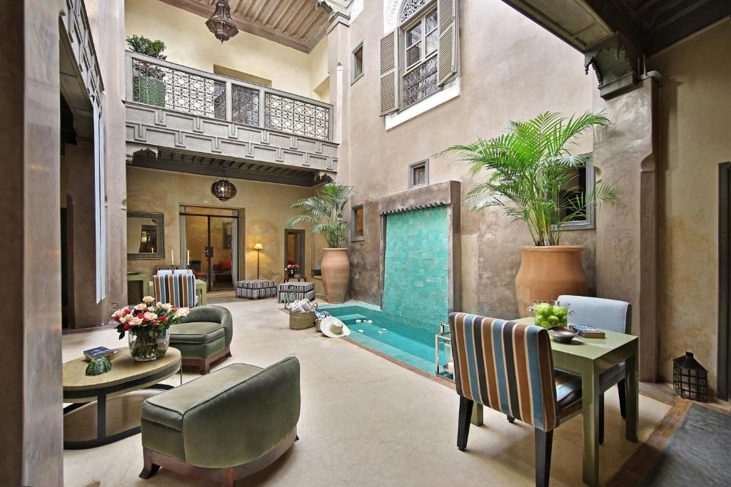 a living room with a pool table and chairs at Riad Dar One in Marrakesh