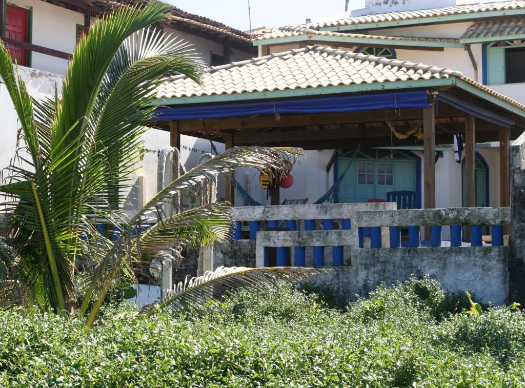 una casa con un porche azul y una palmera en Alfazema Cultural Bed and Breakfast en Arembepe