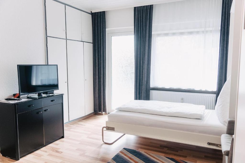 een slaapkamer met een bed, een tv en een raam bij Apartment-EG-07 in Darmstadt