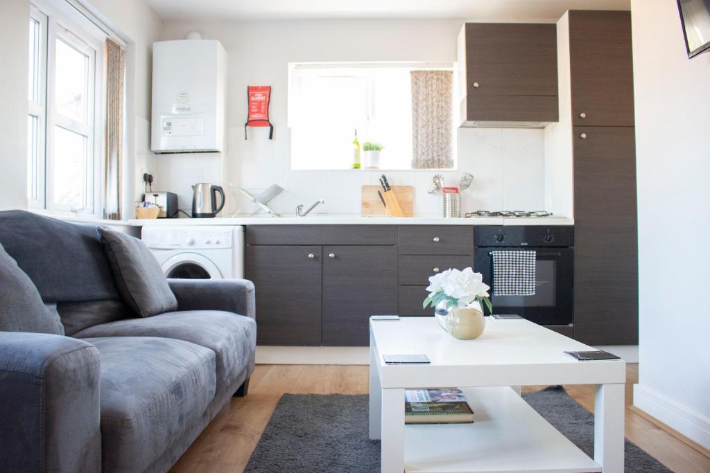 ein Wohnzimmer mit einem Sofa und einem Tisch in der Unterkunft Large 1st Floor Open Plan Apartment in Loughborough