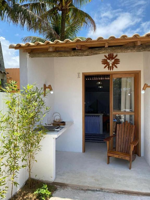 a porch of a house with a chair and a door at Flat Pitaya - Cond. Morada da Praia in Bertioga