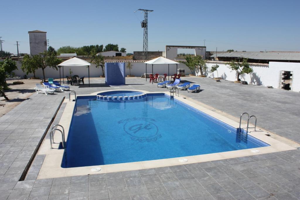 托梅略索的住宿－Hostal El Palomar，一个带椅子和桌子的大型游泳池