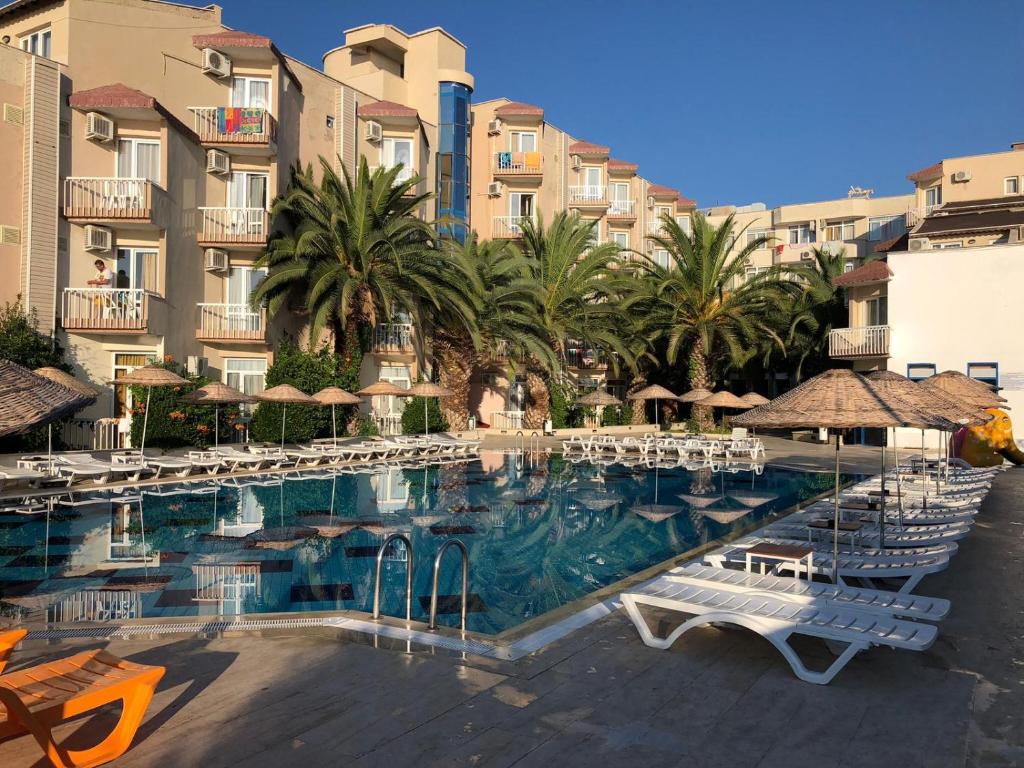 a large swimming pool with chairs and umbrellas at AFYTOS ÖREN PARK MTK in Burhaniye