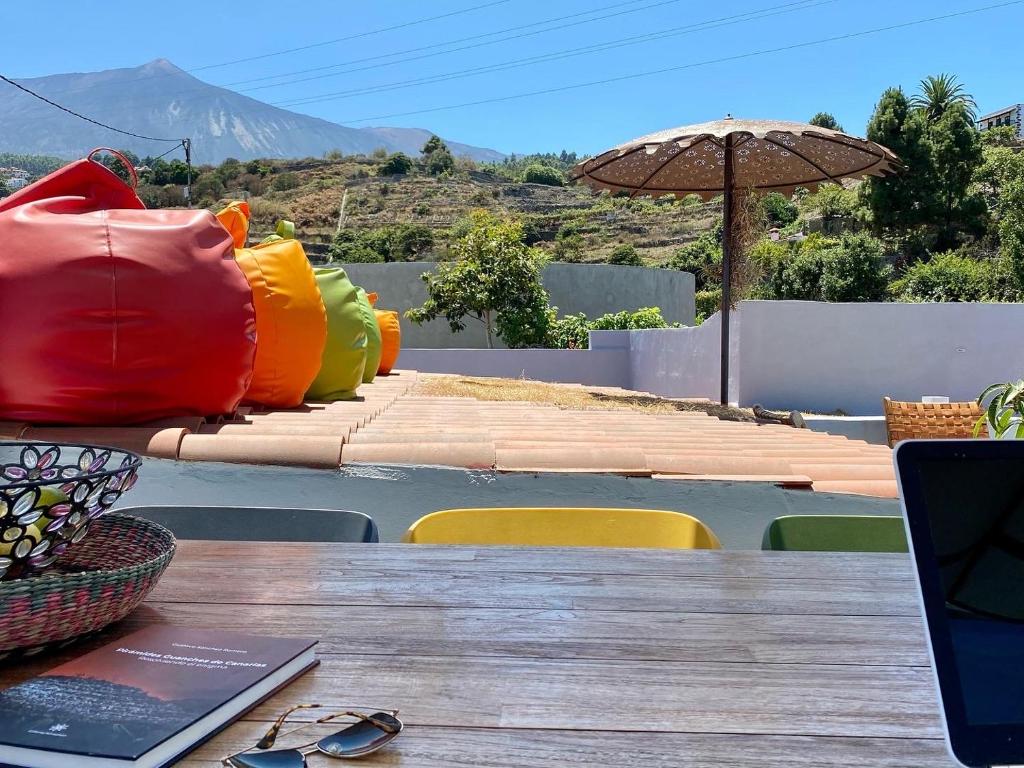 einen Tisch mit einem Laptop auf einem Tisch mit einem Sonnenschirm in der Unterkunft Casa Salvia Guesthouse Icod de los Vinos in Icod de los Vinos