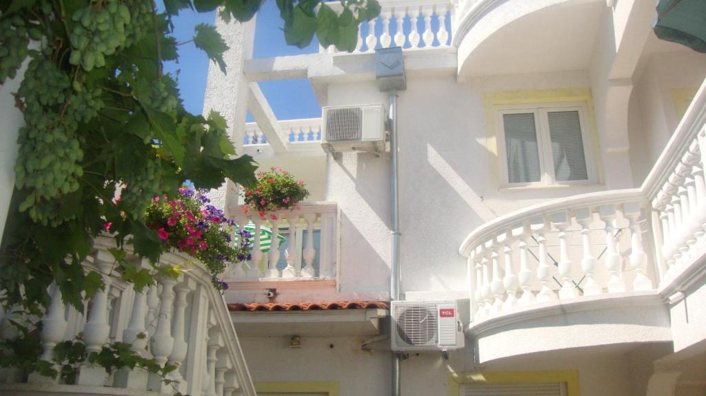 un edificio blanco con un balcón con flores. en Apartments Vodice Marica, en Vodice