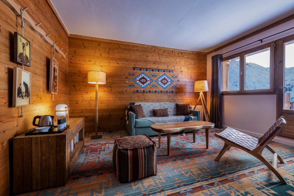 a living room with a couch and a table at Chalet Hotel Kaya in Les Menuires