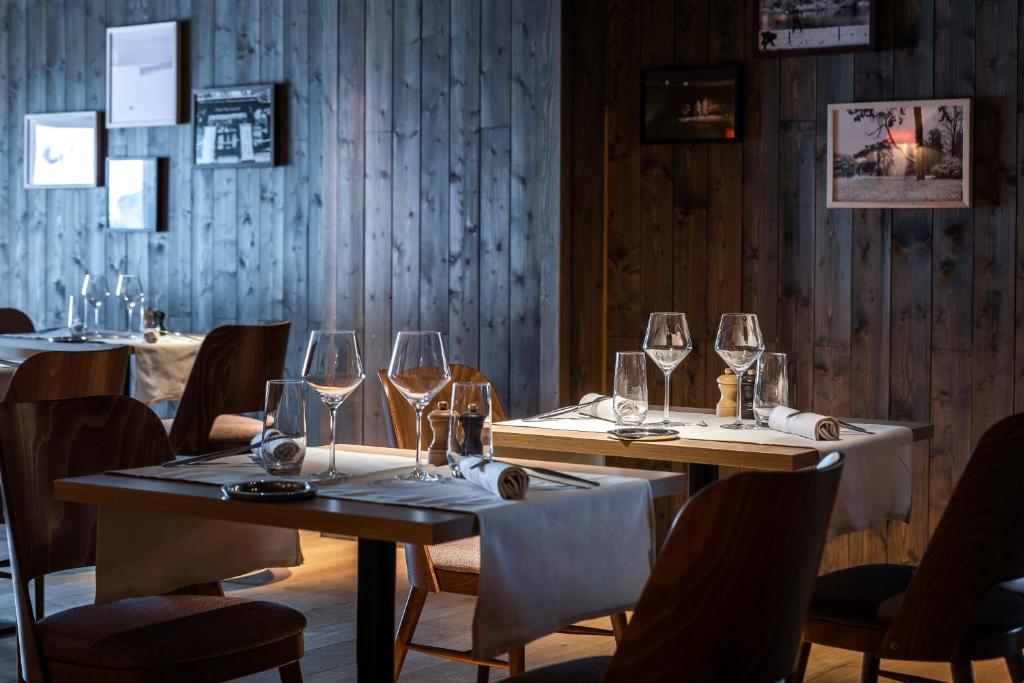 a dining room with two tables with wine glasses at Chalet Hotel Kaya in Les Menuires