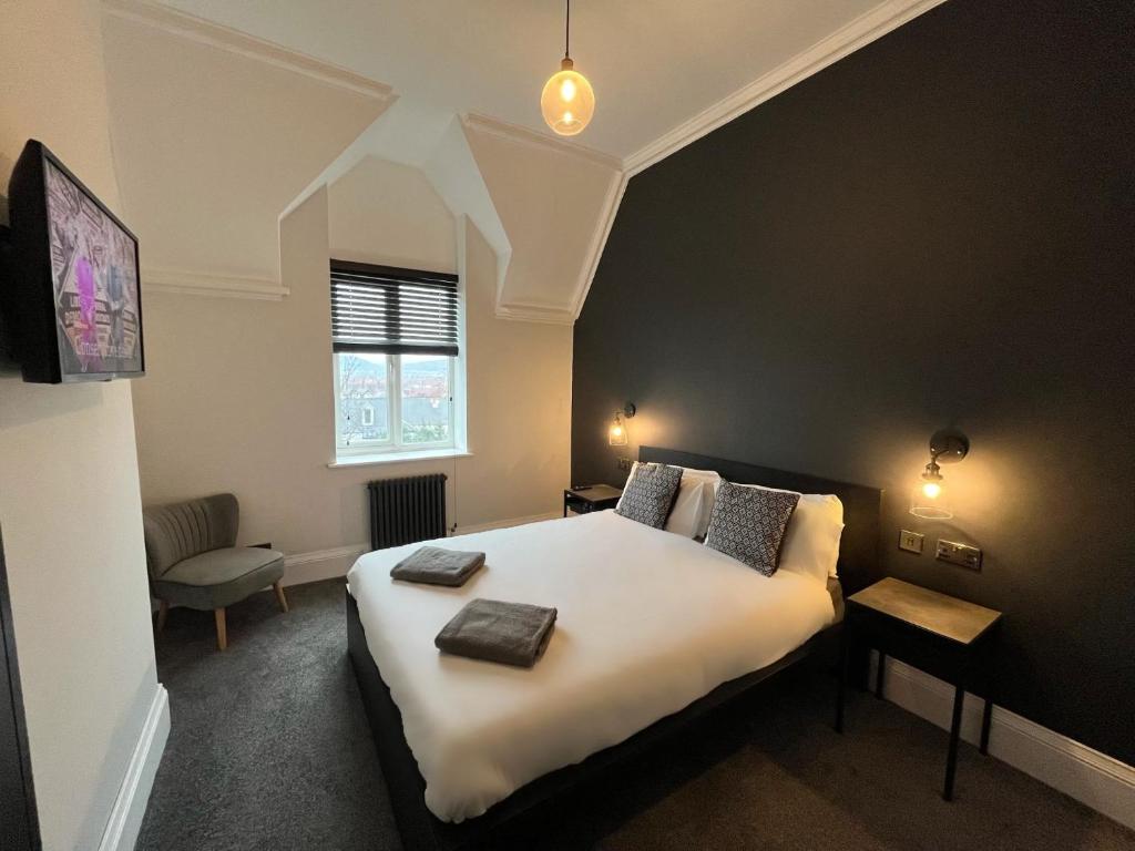 1 dormitorio con 1 cama grande con sábanas blancas y ventana en Ormes Hey Apartments, en Llandudno