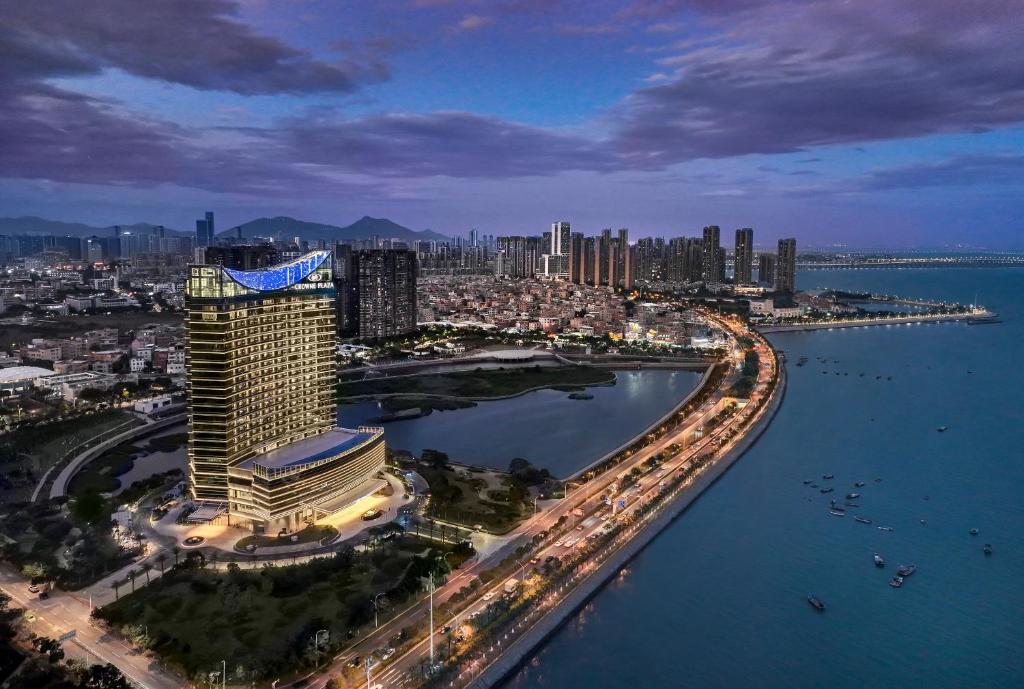 eine Luftansicht einer Stadt mit Gebäuden und Wasser in der Unterkunft Crowne Plaza Xiamen Jimei Seaview, an IHG Hotel-Free Mini Bar in Xiamen