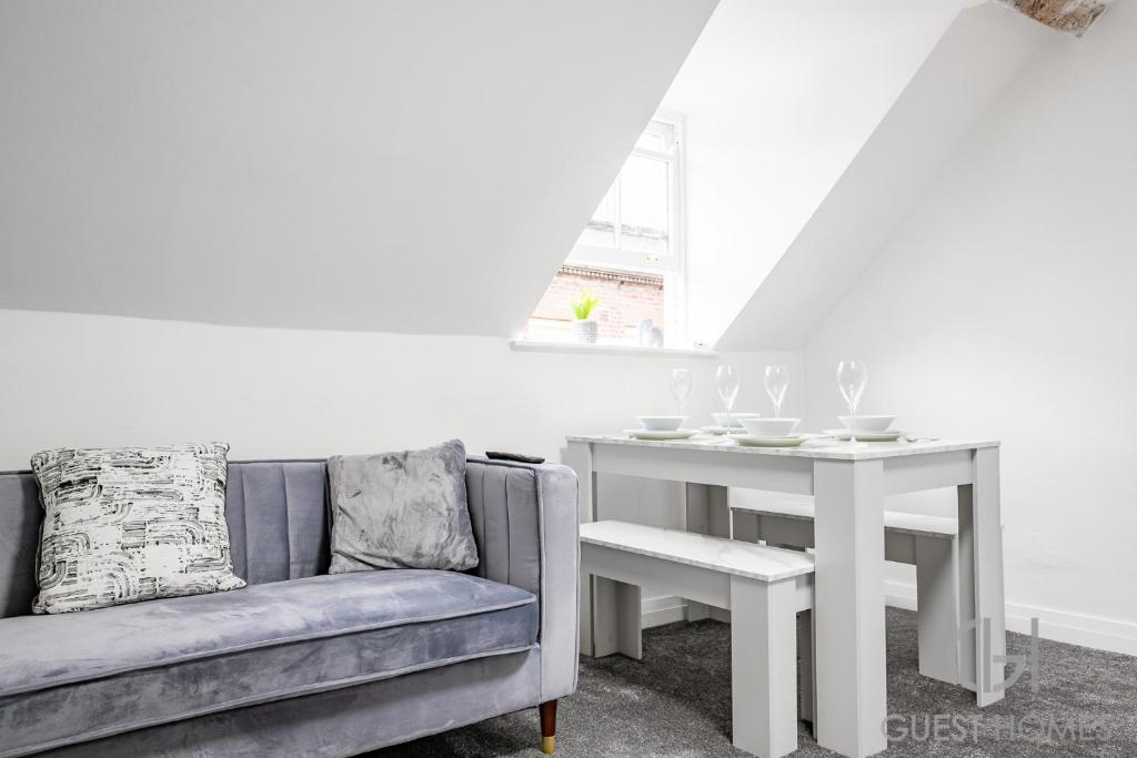 ein Wohnzimmer mit einem Sofa und einem Tisch in der Unterkunft Guest Homes - New Street Dwelling in Worcester