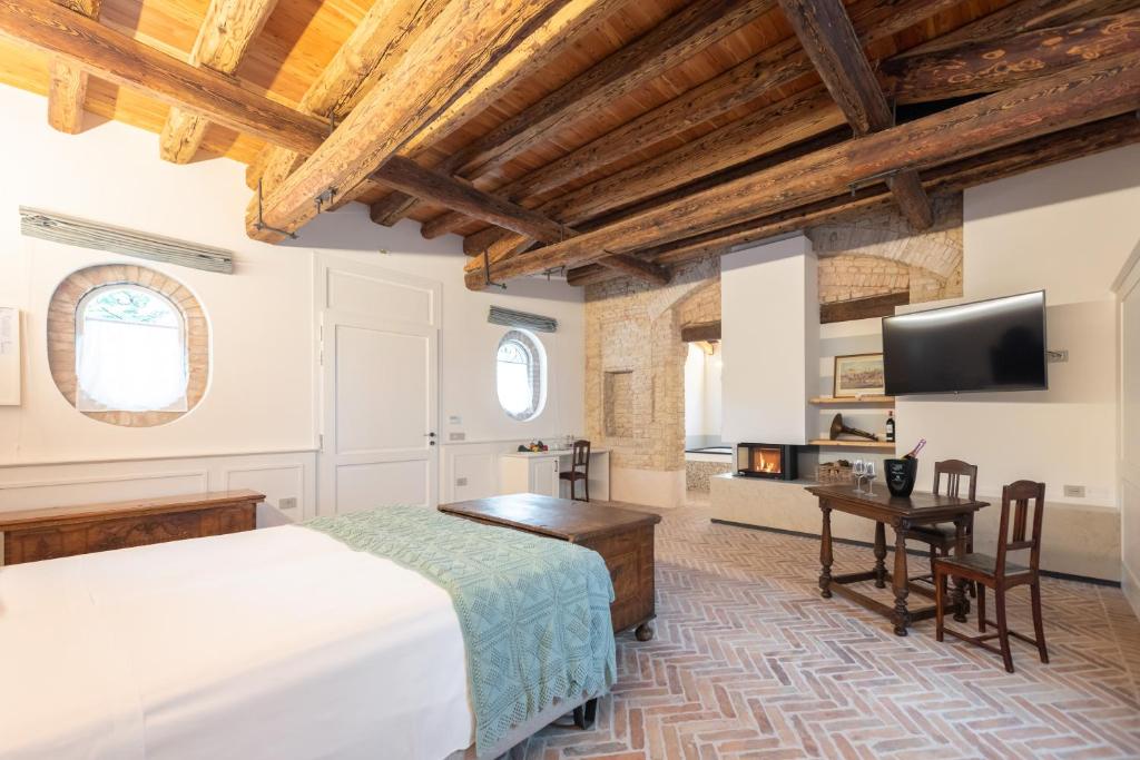 a bedroom with a bed and a desk and a tv at Relais Barchessa Molon in Campo di Pietra