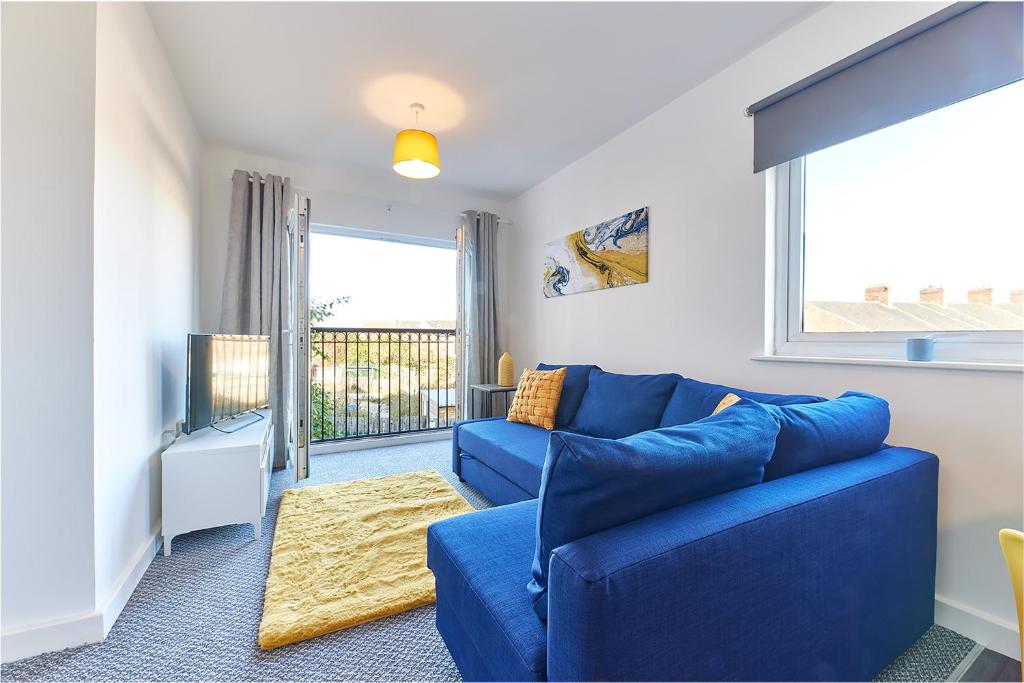 sala de estar con sofá azul y ventana en The Mindrum - Properties Unique en North Shields