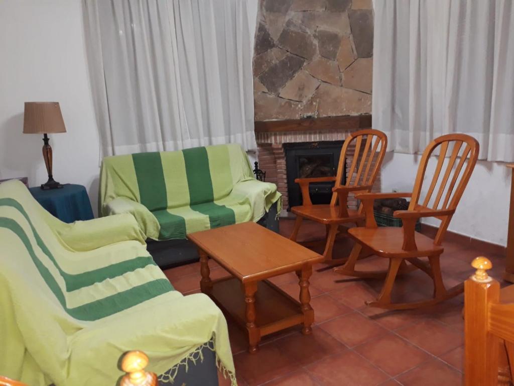 a living room with chairs and a fireplace at Casa Rural Rio Canto in El Hornillo