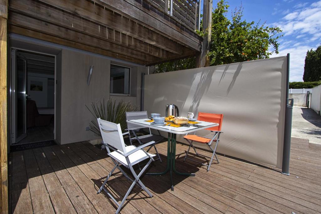 un patio avec une table et des chaises sur une terrasse dans l'établissement Cailloux, à Saint-Cyr-sur-Mer