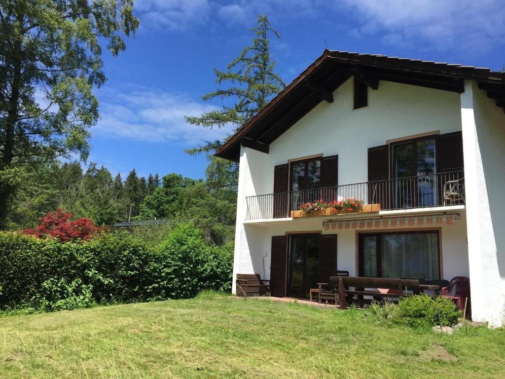 Ferienhaus Endrös - Chiemgau Karte في انزل: بيت أبيض كبير مع شرفة