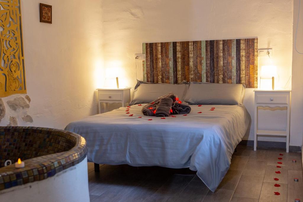 a bedroom with a white bed with two night stands at Fortress Jacuzzi Suites in Xàtiva