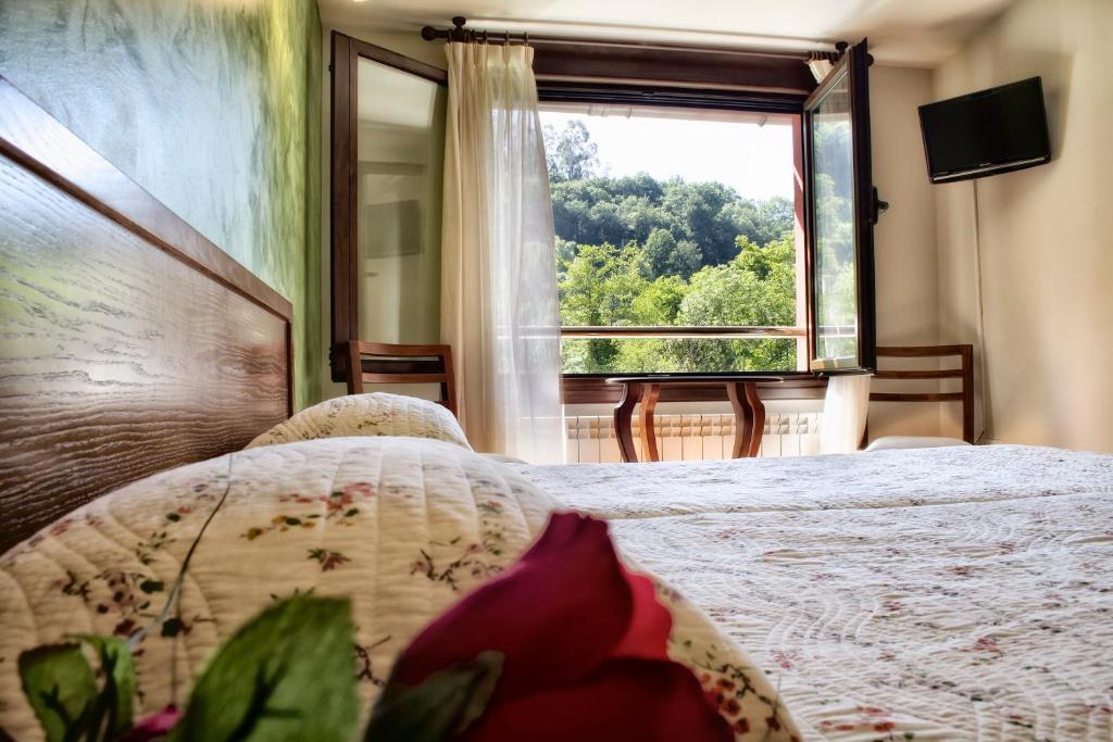 a bedroom with a bed and a large window at Alojamiento Covadonga in Cangas de Onís