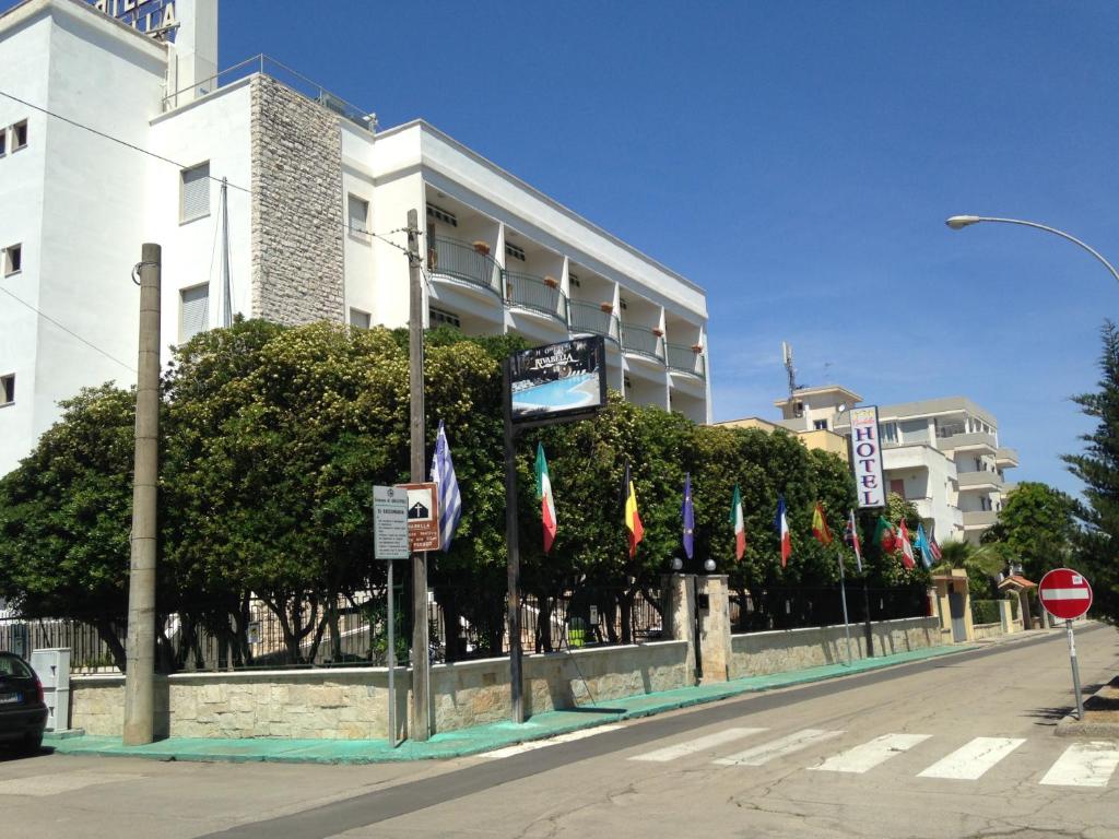 una fila di bandiere di fronte a un edificio di Hotel Rivabella a Gallipoli