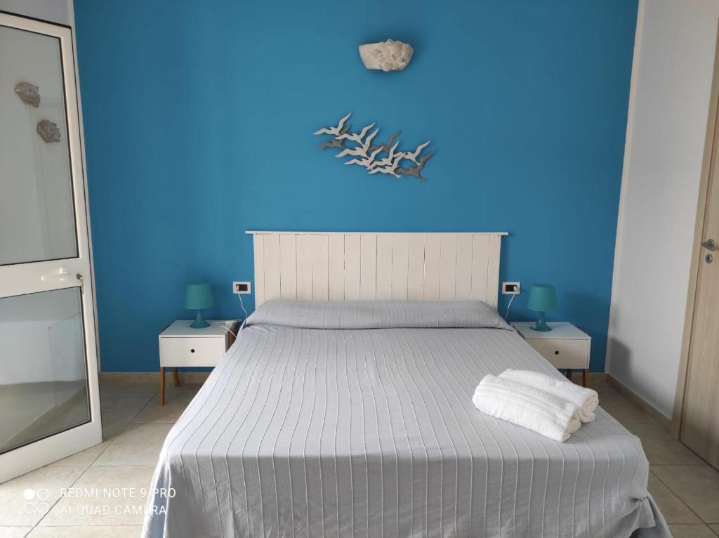 um quarto azul com uma cama e uma parede azul em la lampara em Favignana
