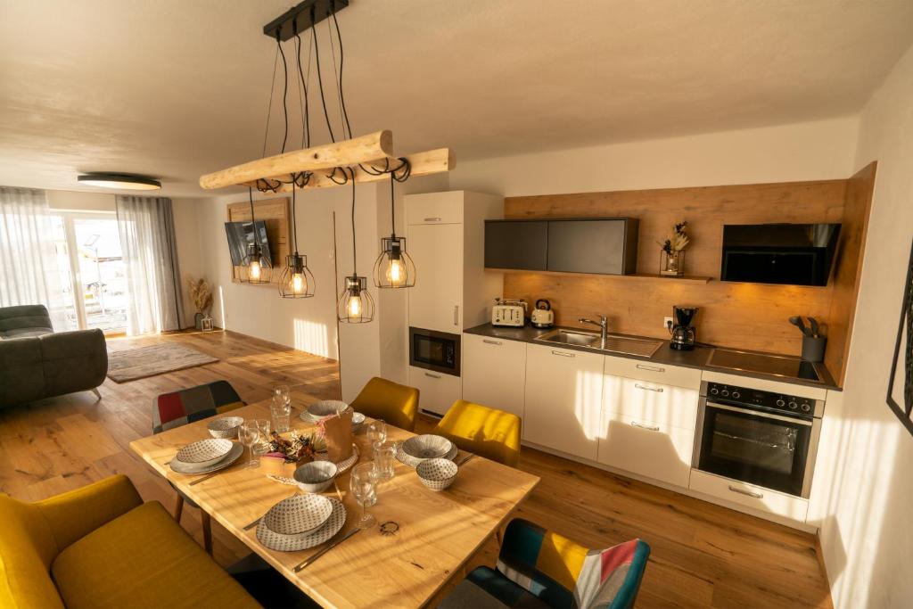 a kitchen and living room with a table and chairs at Bergzauber Appartements in Rennweg