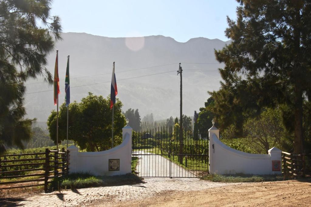 a gate with two flags and a fence at Calais Wine Estate in Paarl