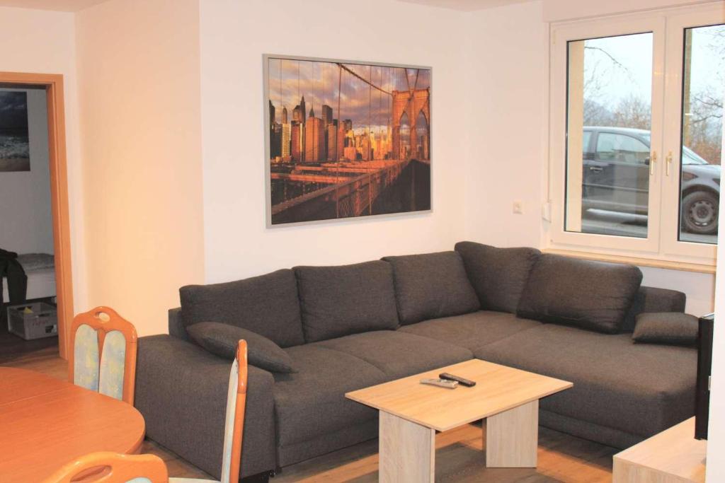 ein Wohnzimmer mit einem Sofa und einem Tisch in der Unterkunft Work & Stay in Jena in Neuengönna